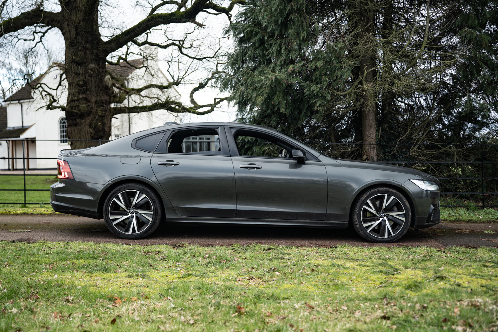 Grey Volvo S90 side profile on a country estate